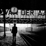 841312 Afbeelding met het silhouet van een wachtende man op het perron van het N.S.-station Amsterdam C.S. te Amsterdam.